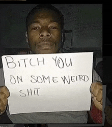 a man is holding a sign that says bitch you on some weird shit