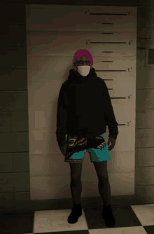 a man wearing a black hoodie and blue shorts is standing in front of a wall with a ruler that says 6 '