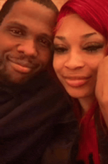 a man and a woman are posing for a picture and smiling for the camera .