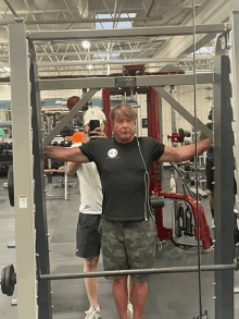 a man is taking a picture of himself in a gym with a phone