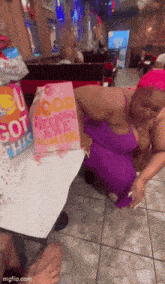a woman in a purple dress is holding a pink gift bag that says " good things are coming "