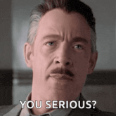 a man with a mustache is making a serious face and saying `` you serious '' .
