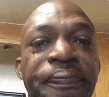 a close up of a man 's face with a tear coming out of his eye .