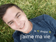 a man laying in the grass with the words j'aime ma vie