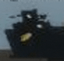 a blurry picture of a large black ship with a yellow light on top of it .