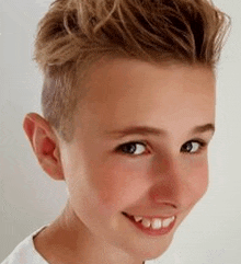 a close up of a young boy 's face smiling .