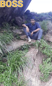 a man sits on a rock with the word boss written above him