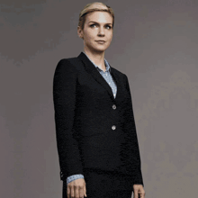 a woman in a suit is standing in front of a wall with a reflection of a dog and the word inn on it