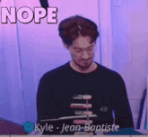 kyle jean baptiste is standing in front of a pink background