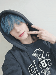 a person with blue hair wearing a black hoodie with the letter b on it