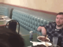 a man is sitting at a table with a plate of food