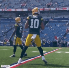 a couple of football players are standing on a field .