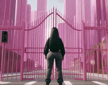 a woman stands in front of a pink fence with a stop sign in front of it