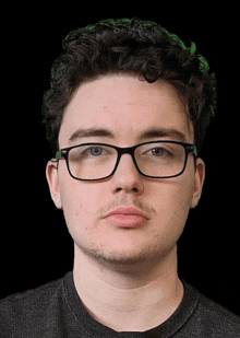 a young man wearing glasses and a black shirt