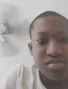 a young man is standing in front of a ceiling fan looking at the camera .