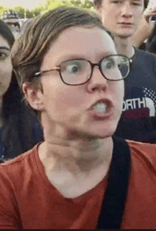 a man wearing glasses is making a funny face with his mouth open .