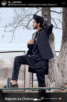 a man in a black suit is leaning against a tree with the words rajputo ka chokra below him