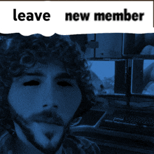 a man with curly hair and a beard is behind a sign that says leave new member on it