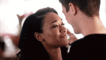 a man and a woman are looking at each other .
