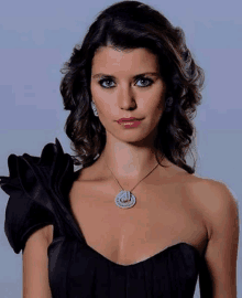 a woman wearing a black dress and a necklace