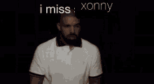 a man with a beard is wearing a white polo shirt with the words i miss xonny above him