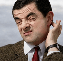 a man in a suit and tie is making a face