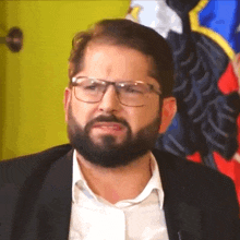 a man with a beard wearing glasses and a white shirt