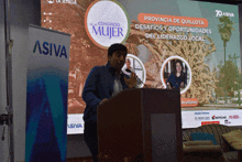 a man stands at a podium in front of a screen that says ' provinsia de quillota ' on it