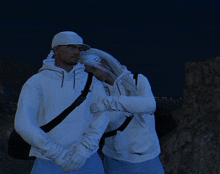 a man and a woman wearing white hoodies and hats