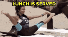 a woman is doing yoga on the beach and the words lunch is served are above her