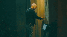 a man is walking down a street with a fire coming out of a window
