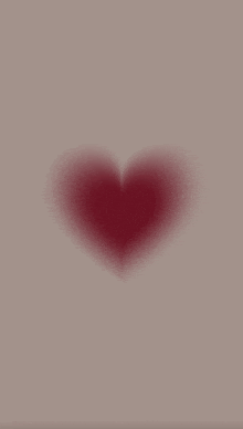 a red heart is floating in the air on a gray background .