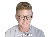 a man wearing glasses is smiling and saying " okay "