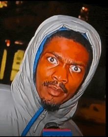 a man wearing a hooded jacket looks at the camera with his eyes wide open