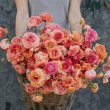 a person is holding a basket full of flowers