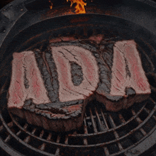 a steak is cooking on a grill with the word mom written on it