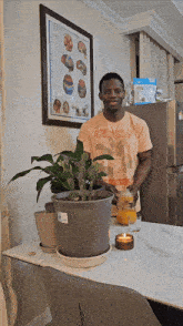 a man standing in front of a table with plants and a poster on the wall that says ' homeopathy '