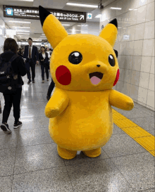 a person in a pikachu costume is standing in a subway station