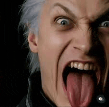 a close up of a man making a funny face with his tongue out .