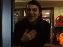 a man giving a thumbs up in front of a door that says stot on it