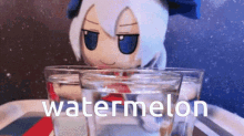 a stuffed animal is holding a glass of water next to a glass of watermelon