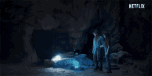 two people standing in a cave with a netflix logo in the corner