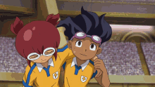 a boy and a girl are standing next to each other and the boy has a lightning bolt on his uniform