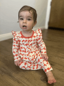 a baby wearing a red and white outfit with snowmen on it