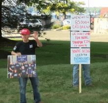 a man is holding a sign that says trump 2016