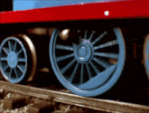 a close up of a blue train wheel on a train track