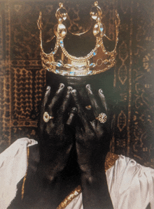 a man with a crown on his head is covering his face