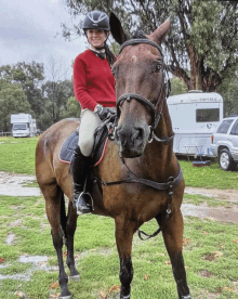 a woman riding a brown horse in front of an imperial caravan