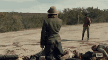 a woman in a hat stands in front of a pile of dead people and a sign that says ' амс '