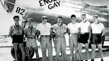 a group of men standing in front of an airplane .